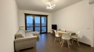 a living room with a couch and a table and chairs at Urban Nest Living in Sesto San Giovanni