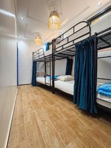 a room with two bunk beds and a wooden floor at Blue Pearl Surf & Yoga House in Tamraght Ou Fella