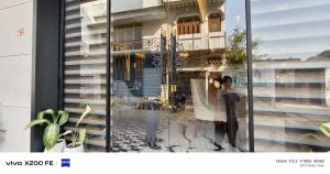 a window with a reflection of a building at Hotel Velina in Dhāmpur