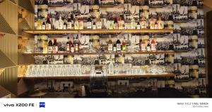 a wall filled with lots of bottles and glasses at Hotel Velina in Dhāmpur