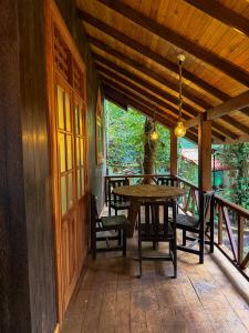a porch with a wooden table and chairs on it at Orelia villas in Badulla