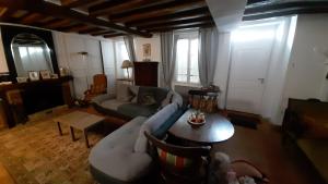 a living room with a couch and a table at Maison avec cour et jardin in Marolles-sur-Seine
