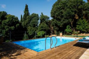 a swimming pool with a wooden deck next to at Villa Mila with private pool by Olivestone Village in Ágios Márkos