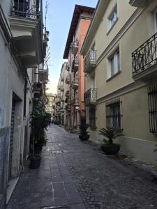 an empty street with buildings and potted plants on the side at Bis Jolly 1 in Cosenza
