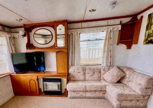 a living room with a couch and a tv at No 26 Mountain View in Cockermouth