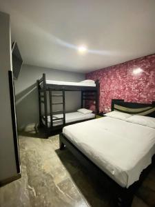 a bedroom with two bunk beds and a pink wall at Hotel Mi Palermo in Bucaramanga