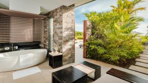 a bathroom with a tub and a garden at InterContinental Fiji Golf Resort & Spa by IHG in Natadola