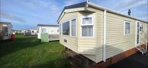 a yellow house on the side of a yard at BILOT Caravan in Heysham
