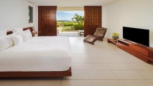 a bedroom with a large bed and a flat screen tv at InterContinental Fiji Golf Resort & Spa by IHG in Natadola