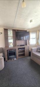 a living room with a fireplace and a tv at BILOT Caravan in Heysham