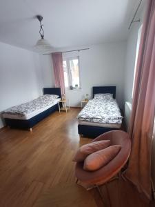 a room with two beds and a chair in it at Domek nad Sołą in Cisiec