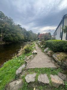 a path next to a river next to a building at Edwards cabin in Caeathro