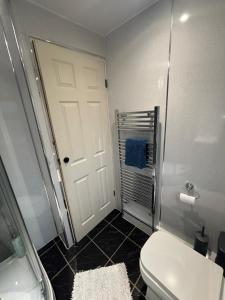 a bathroom with a white toilet and a door at Edwards cabin in Caeathro +16 photos