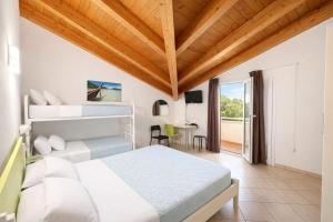ein Schlafzimmer mit zwei Betten und einem Tisch mit Stuhl in der Unterkunft Hotel Sasselli Dipendenza Hotel Zamagna in Cesenatico