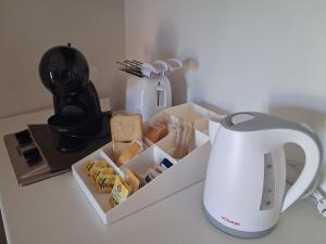 a tea kettle and a box of food on a counter at Mivida "Le stanze di Ada" in San Teodoro