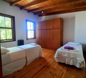 a bedroom with two beds and a wooden floor at Tranquilidad en Bragado in Bragado