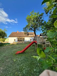 a red slide in a yard in front of a house at WERK 2 - B&B Ecoturistic - Saschiz in Saschiz