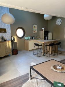 a living room with a table and a kitchen at La P'tite Bicoque in Doizieux