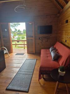 a bedroom with a bed and a tv on a wooden wall at Cabanas das Oliveiras in Torres
