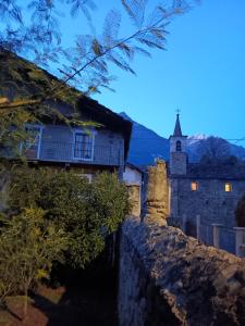 an old building with a church in the background at La Casa Antica in Pont-Saint-Martin