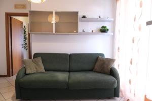a green couch sitting in a living room at Casa Segantini - Relax Apartment 2 in Arco