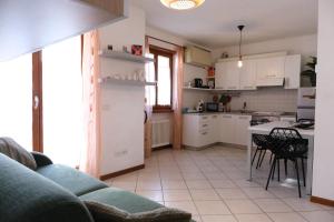 a kitchen with a couch and a table with chairs at Casa Segantini - Relax Apartment 2 in Arco +29 photos