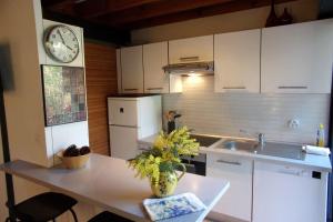 a kitchen with a table and a clock on the wall at Beautiful 67 m duplex with gardengolf view in Moliets-et-Maa