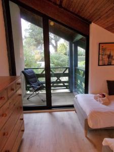 a bedroom with a bed and a balcony with a chair at Beautiful 67 m duplex with gardengolf view in Moliets-et-Maa +15 photos