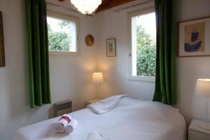 a bedroom with green curtains and a bed with shoes on it at Beautiful 67 m duplex with gardengolf view in Moliets-et-Maa
