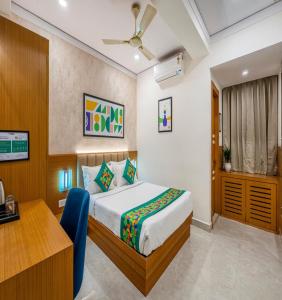 a hotel room with a bed and a desk at The Kalvin Plaza in New Delhi