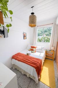 a bedroom with a bed and a window at Pousada Surf na Guarda in Guarda do Embaú