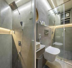 a bathroom with a shower and a toilet and a sink at The Kalvin Plaza in New Delhi