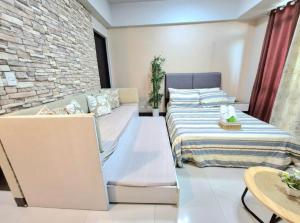 a bedroom with a bed and a brick wall at STUDIO TYPE CEBU CITy in Cebu City