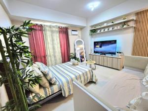 a living room with a couch and a flat screen tv at STUDIO TYPE CEBU CITy in Cebu City
