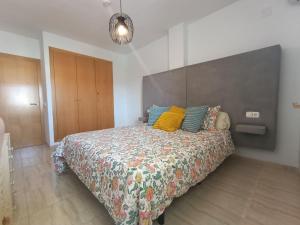a bedroom with a large bed with colorful pillows at ALMERIMAR GOLF AND PoOL APARTMENT in Almerimar +23 photos