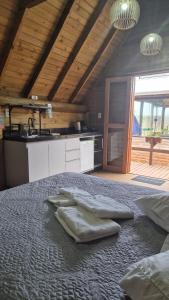 a bedroom with a bed with two towels on it at Cabanas das Oliveiras in Torres