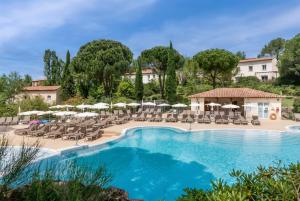 a resort pool with chairs and umbrellas at Village Pierre & Vacances Le Rouret in Grospierres