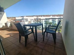 a table and two chairs on a balcony at ALMERIMAR GOLF AND PoOL APARTMENT in Almerimar