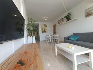 a living room with a couch and a table at ALMERIMAR GOLF AND PoOL APARTMENT in Almerimar