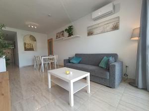 a living room with a couch and a table at ALMERIMAR GOLF AND PoOL APARTMENT in Almerimar