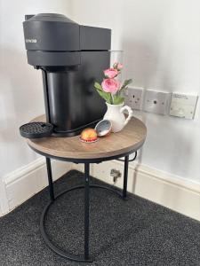a coffee maker and a vase with flowers on a table at Leamington Spa Boutique Two Bedroom Flat in Leamington Spa