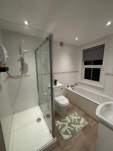 a bathroom with a shower and a toilet and a sink at Leamington Spa Boutique Two Bedroom Flat in Leamington Spa +13 photos