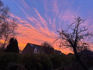 a sunset with a house and clouds in the sky at Leamington Spa Boutique Two Bedroom Flat in Leamington Spa