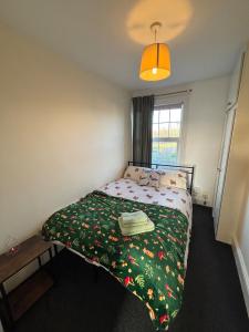 a bedroom with a bed with a green blanket at Leamington Spa Boutique Two Bedroom Flat in Leamington Spa