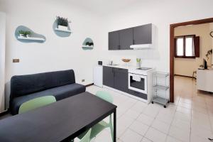 a living room with a couch and a kitchen at Santa Caterina 3 - San Bernardo in Crema