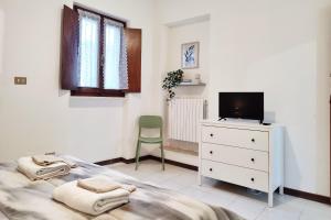 a bedroom with a bed and a tv on a dresser at Santa Caterina 3 - San Bernardo in Crema