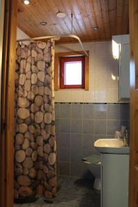 a bathroom with a shower curtain made out of logs at Scandinavian Dream Cottages Vikajarvi- Rovaniemi in Vikajärvi +55 photos