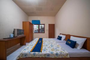 a bedroom with two beds and a tv in it at Griya Astoeti By ARBA in Kopo 2 +16 photos