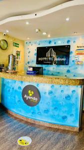 a hotel lobby with a blue counter with a hotel sign at Hotel Mi Palermo in Bucaramanga