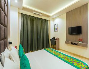 a hotel room with a bed and a television at The Kalvin Plaza in New Delhi